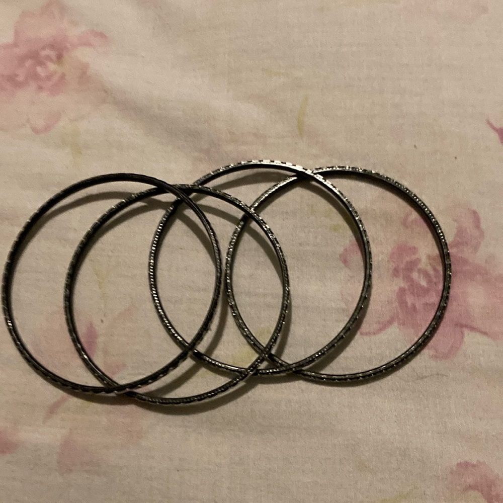 4 black and silver bangle bracelets.